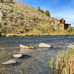 Old house sits on the hillside along a river